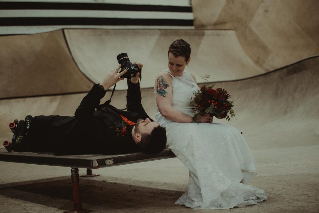 groom taking a photo of his wife