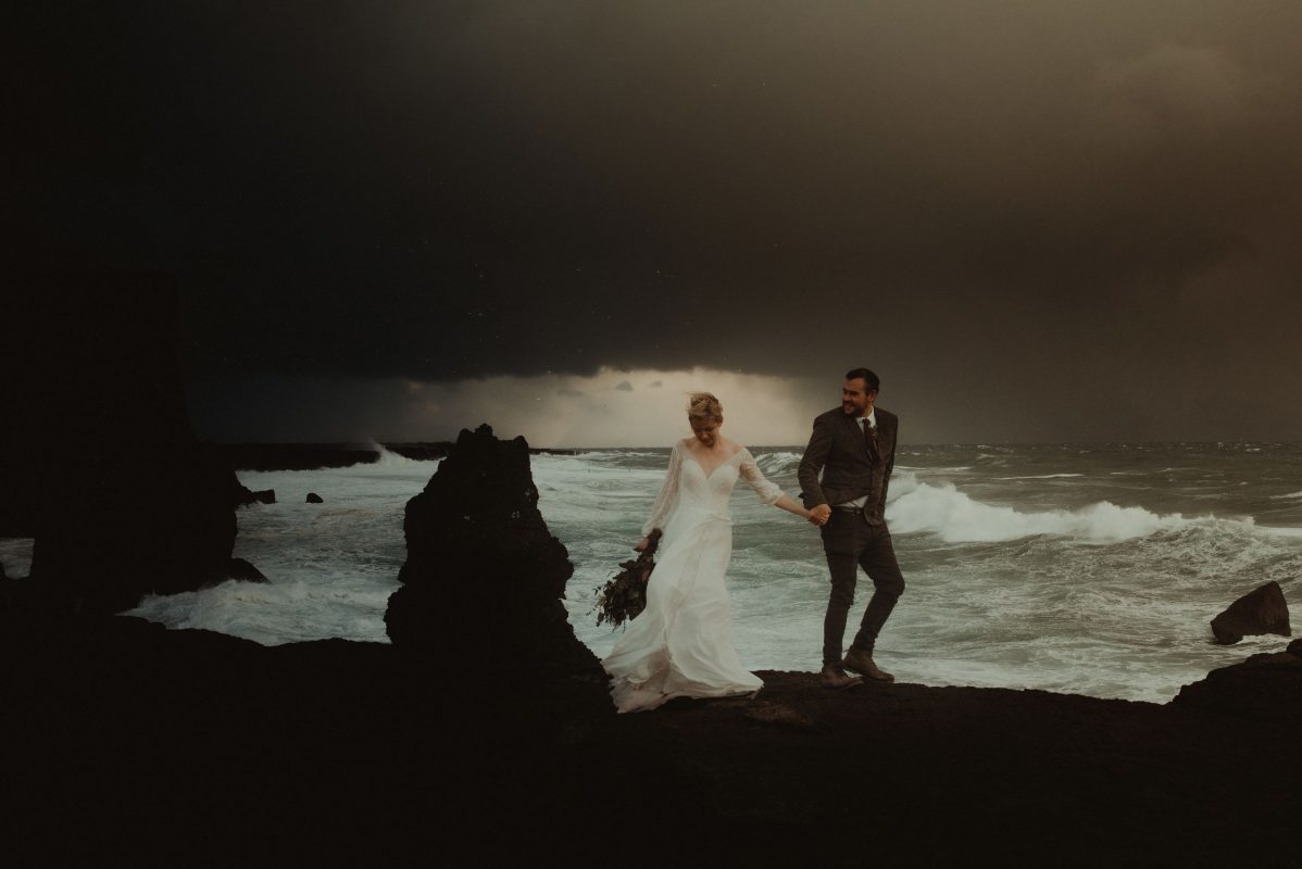 Dramatic Iceland wedding portrait of a couple posing by the waves