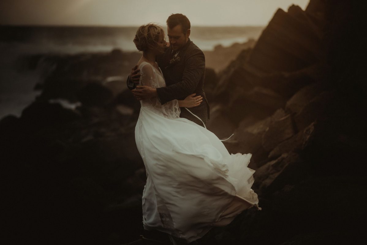 Dramatic Iceland wedding portrait of a couple posing in a sunset