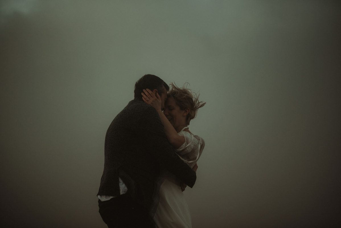 Wedding portrait of a couple in Iceland kissing in the smoke of a geysir