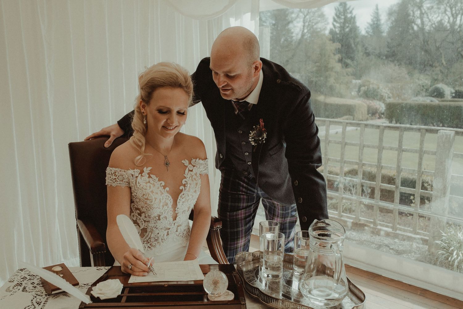 Bride and groom signing the wedding register at Elsick House